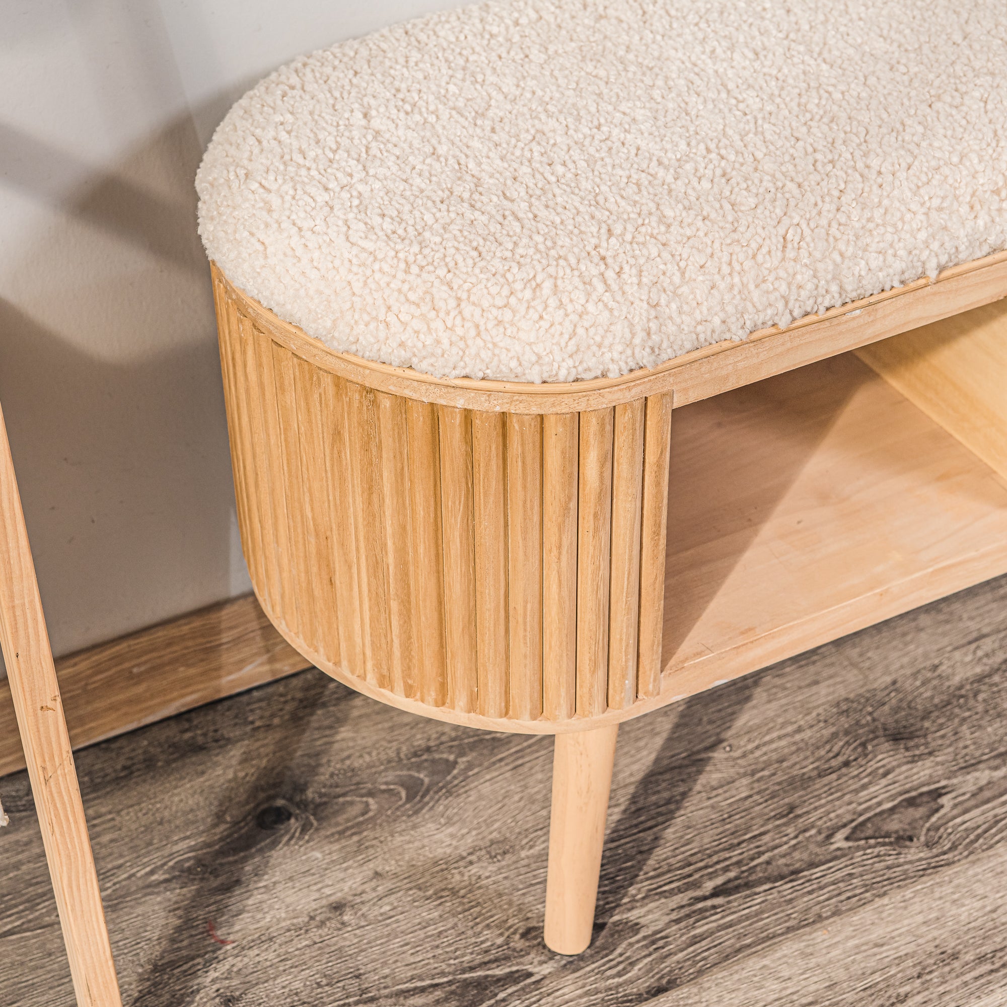 Ławka funkcją przechowywania, wykonana z rattanu i białych pętelek